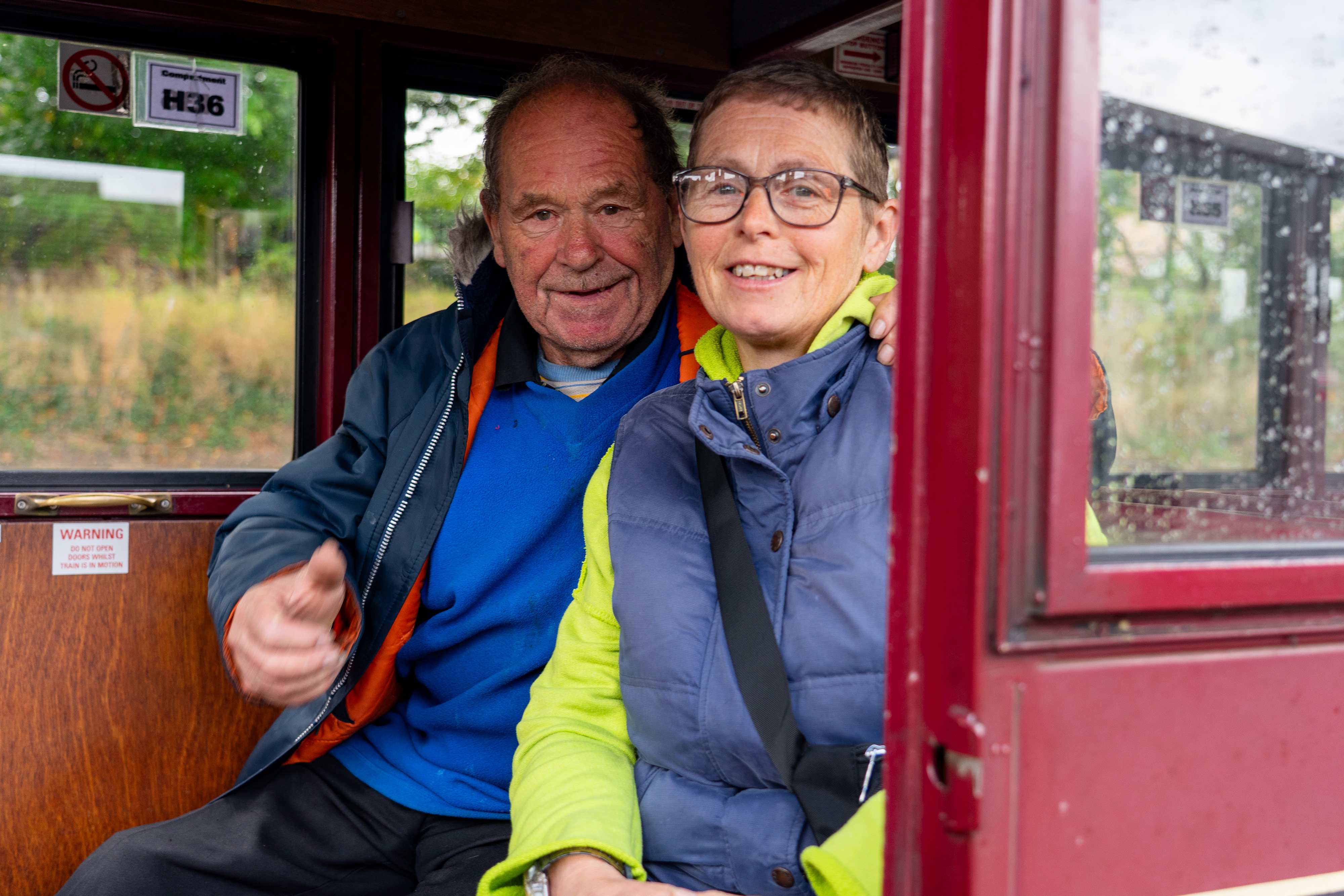 A couple travelling in a carriage on the Bure Valley Railway